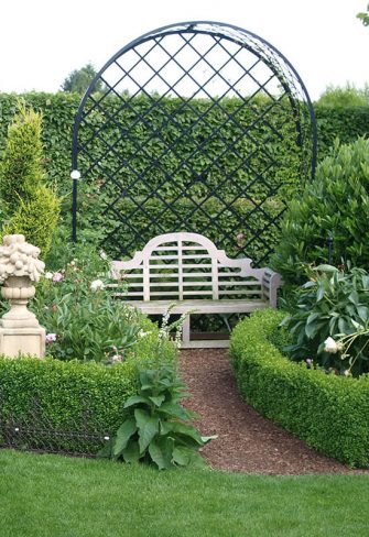 The Villandry Rose Metal Arbour by Classic Garden Elements with a garden bench