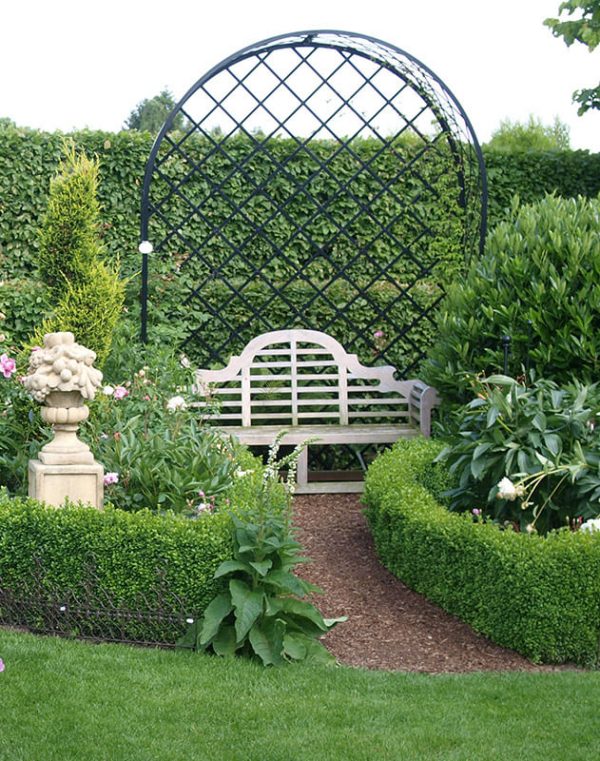 The Villandry Rose Metal Arbour by Classic Garden Elements with a garden bench