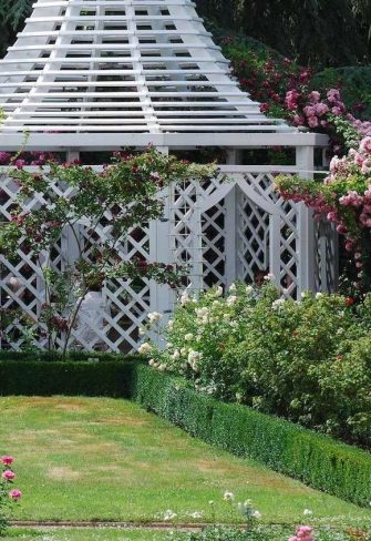 The Zweibrueck Wrought-Iron Gazebo by Classic Garden Elements covered in pink roses
