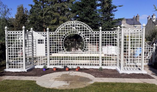 The installation of a Classic Garden Elements Trianon Rose Treillage Set in a garden in Ireland