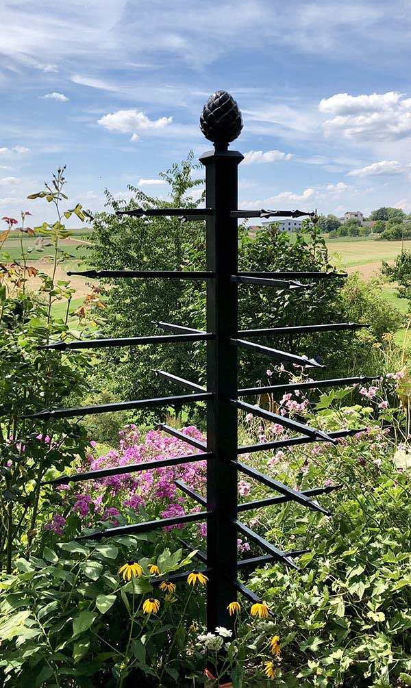 Unusual metal garden obelisk adorned with 28 arrow-shaped horizontal bars