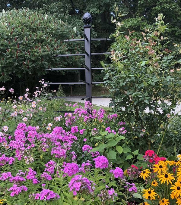 The freestanding Geneva Garden Obelisk by Classic Garden Elements in a vibrant private garden