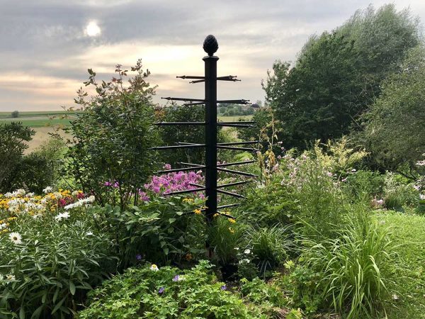 The freestanding Geneva Garden Obelisk by Classic Garden Elements surrounded by plants