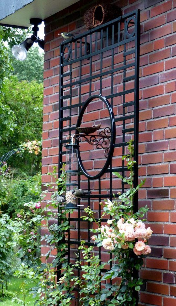 The Knebworth House Metal Wall Trellis in black, mounted on a brick wall