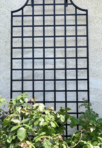 Narrow metal garden trellis with a classic design