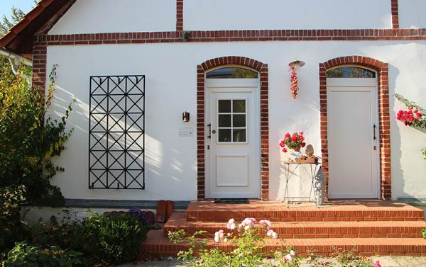 The Ravenna Metal Wall Trellis by Classic Garden Elements on a white house façade