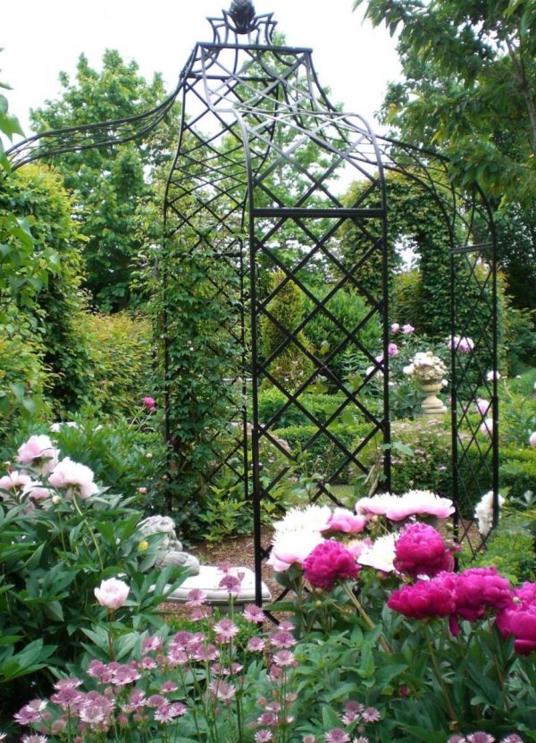 The Kiftsgate Gazebo by Classic Garden Elements surrounded by pink flowers