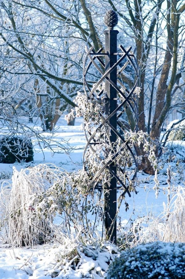 The Charleston Rose Obelisk covered in hoar frost in a snowy garden