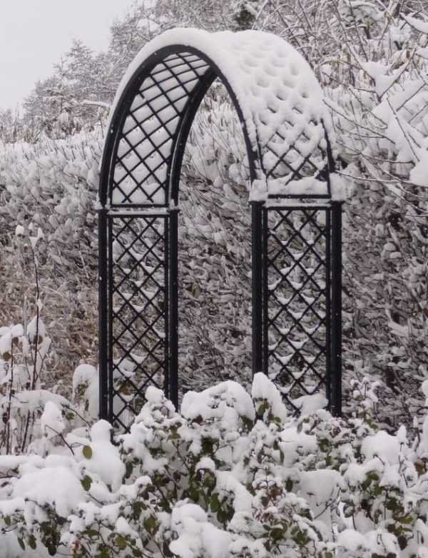 The Portofino Romanesque Garden Arch by Classic Garden Elements covered in snow
