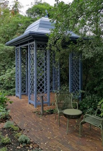 Classic Garden Elements' Wallingford Gazebo with full roof next to a garden seating area