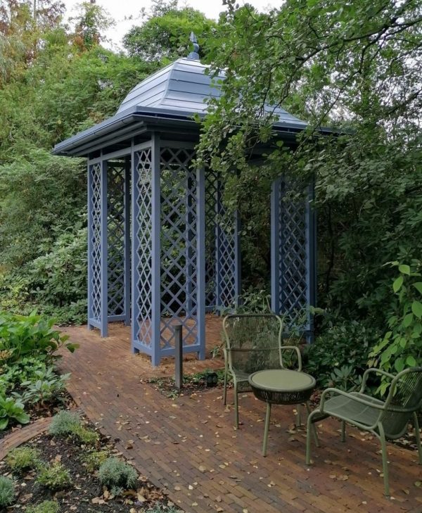 Classic Garden Elements' Wallingford Gazebo with full roof next to a garden seating area