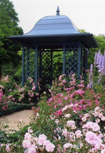 Classic Garden Elements' Wallingford Gazebo with full roof surrounded by borders of flowering pink roses