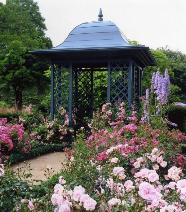 Classic Garden Elements' Wallingford Gazebo with full roof surrounded by borders of flowering pink roses